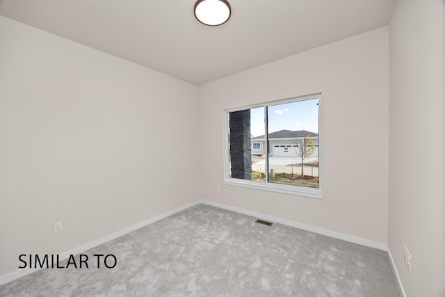 carpeted spare room featuring baseboards and visible vents