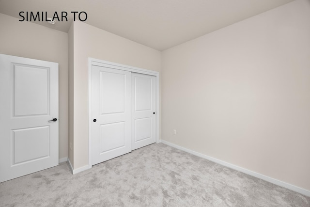 unfurnished bedroom featuring a closet, baseboards, and carpet flooring