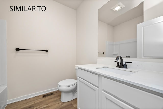 bathroom with vanity, wood finished floors, visible vents, baseboards, and toilet