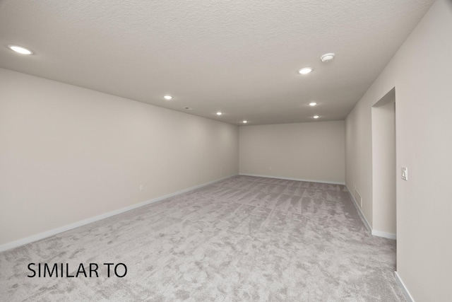 interior space featuring a textured ceiling, recessed lighting, baseboards, and light carpet