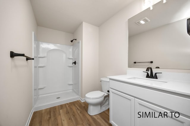 full bath featuring visible vents, toilet, wood finished floors, walk in shower, and vanity