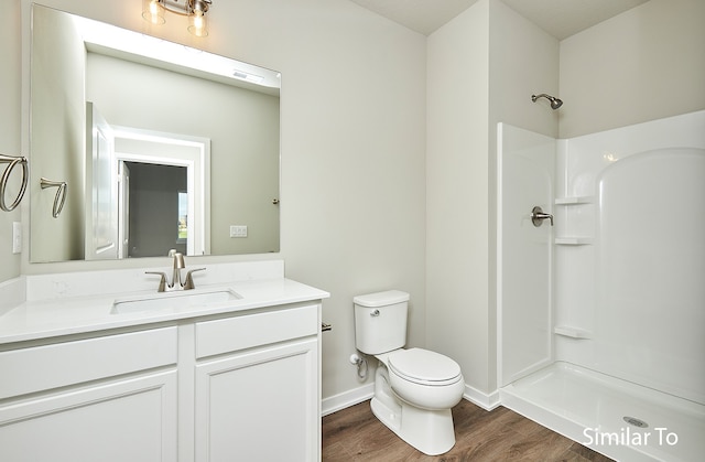 bathroom with a shower, wood-type flooring, vanity, and toilet