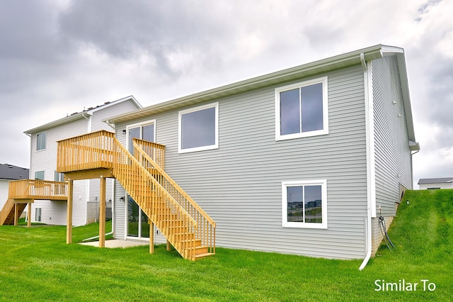 rear view of house with a yard and a deck