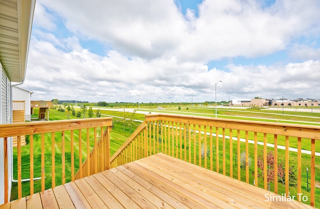 wooden deck featuring a lawn