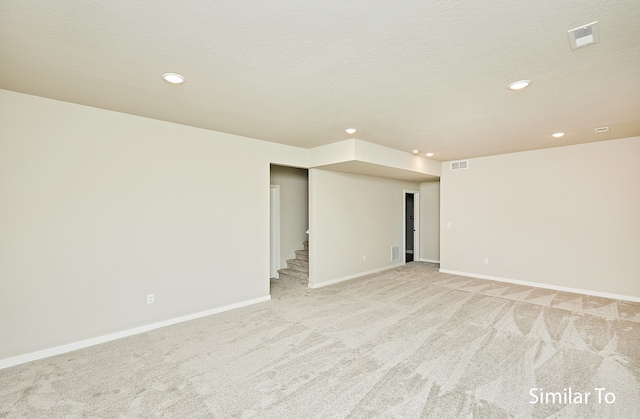 carpeted spare room with a textured ceiling