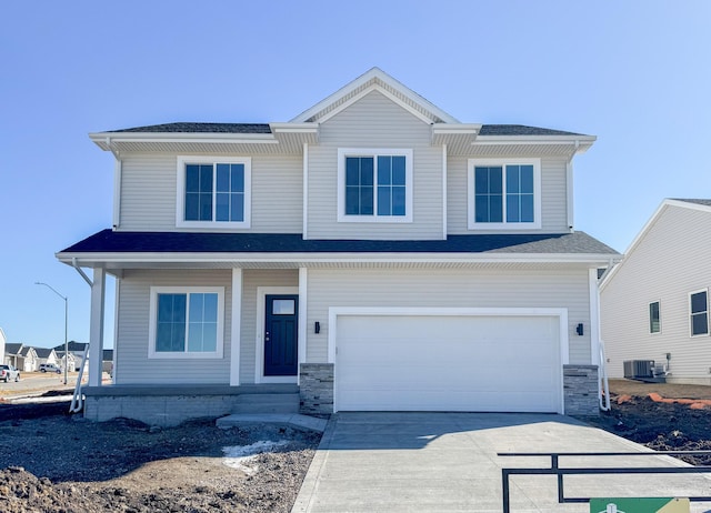 view of front of house with central air condition unit, an attached garage, and driveway