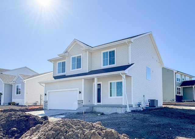 traditional home featuring cooling unit, concrete driveway, and a garage