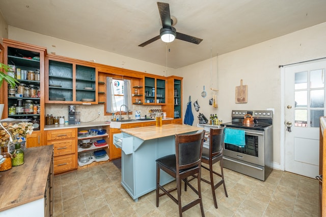 kitchen with decorative backsplash, a breakfast bar, electric stove, butcher block countertops, and a kitchen island