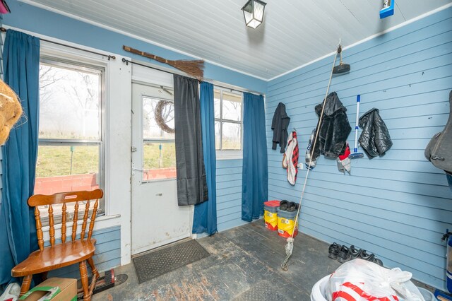 doorway to outside with wooden walls