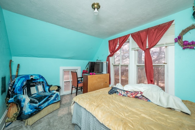 carpeted bedroom featuring a textured ceiling and vaulted ceiling