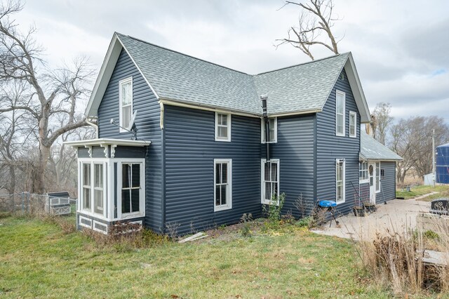 back of house with a lawn and a sunroom