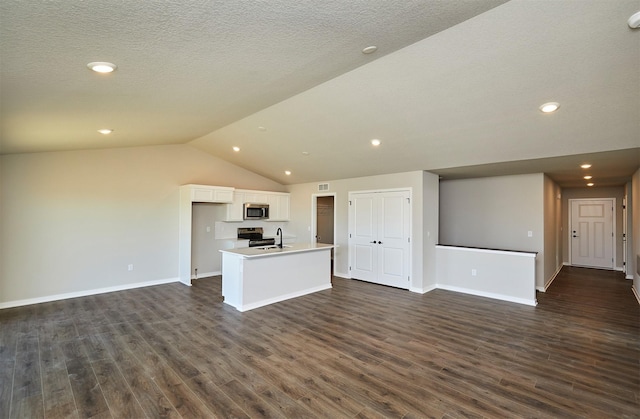 kitchen featuring dark wood-style floors, appliances with stainless steel finishes, open floor plan, and white cabinetry