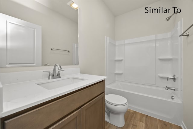 full bathroom featuring hardwood / wood-style flooring, vanity, toilet, and washtub / shower combination