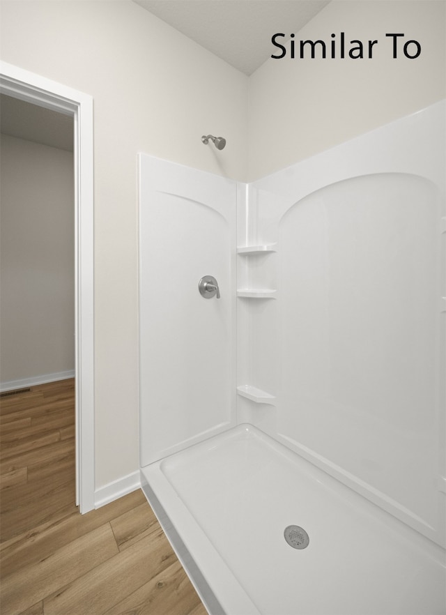 bathroom with a shower and hardwood / wood-style flooring