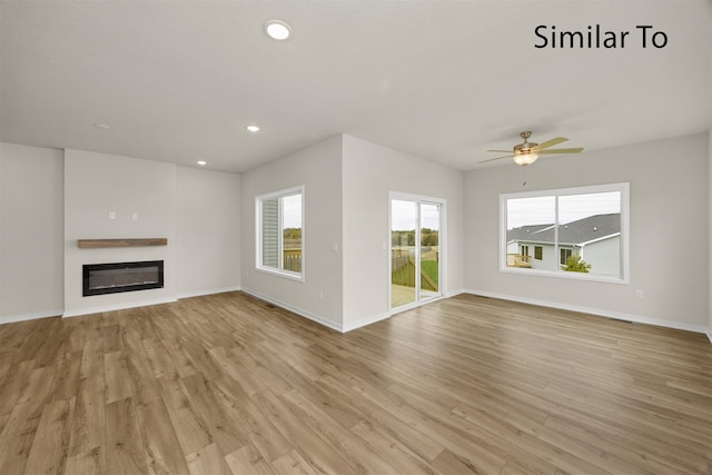 unfurnished living room featuring ceiling fan, plenty of natural light, and light hardwood / wood-style floors