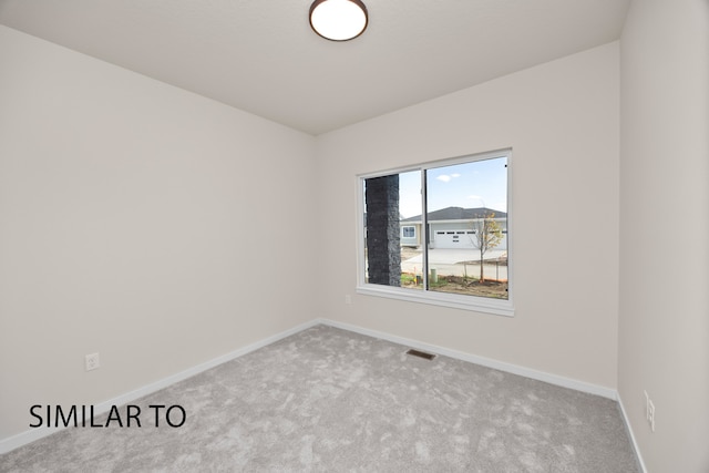 unfurnished room featuring light colored carpet