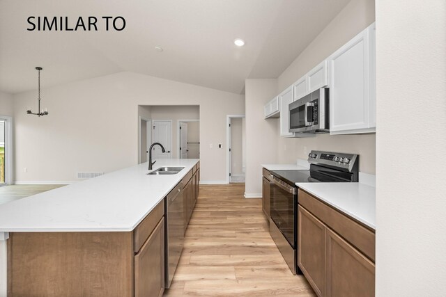 kitchen with light hardwood / wood-style floors, white cabinetry, stainless steel appliances, and an island with sink