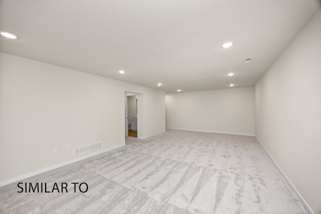 unfurnished room featuring light carpet