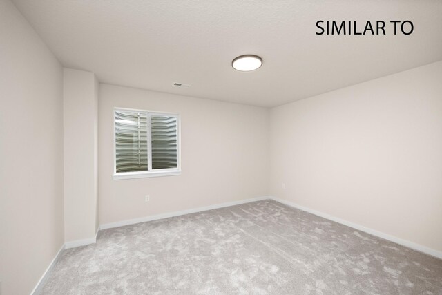 unfurnished room featuring light colored carpet