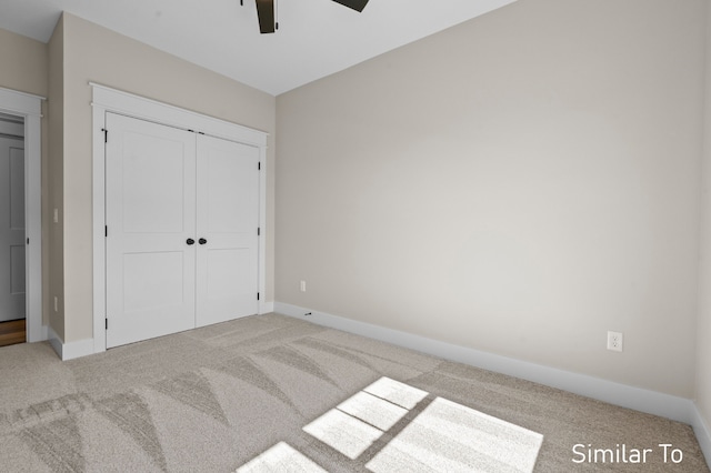 unfurnished bedroom featuring ceiling fan, a closet, and light carpet