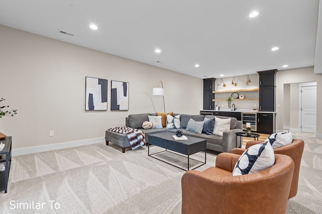 carpeted living room featuring bar area and wine cooler