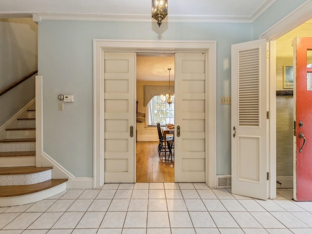 entrance foyer with crown molding, light tile patterned floors, and a notable chandelier