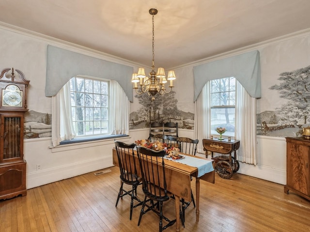 dining space with light hardwood / wood-style floors, an inviting chandelier, and a healthy amount of sunlight