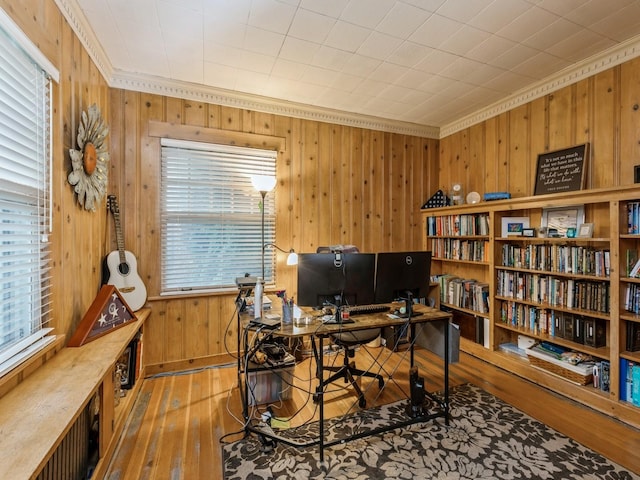 office area with wood walls, hardwood / wood-style floors, a healthy amount of sunlight, and ornamental molding