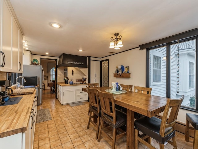 tiled dining space with a notable chandelier and crown molding