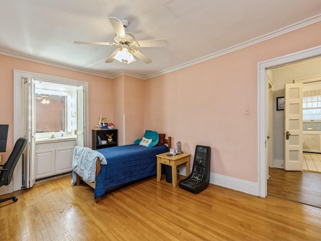 bedroom featuring light wood-type flooring, ensuite bathroom, ceiling fan, crown molding, and sink