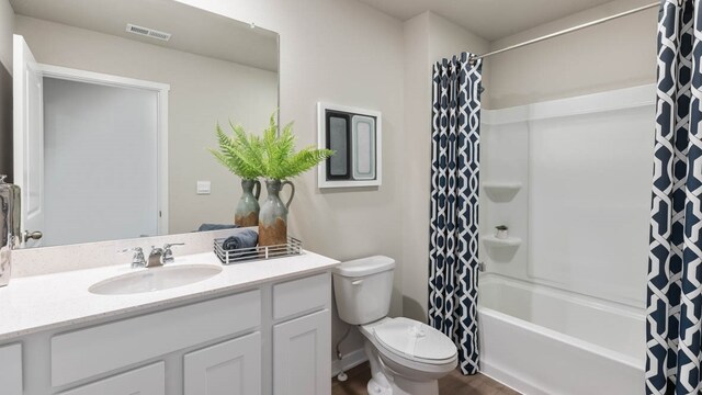 full bathroom with toilet, hardwood / wood-style floors, vanity, and shower / tub combo with curtain