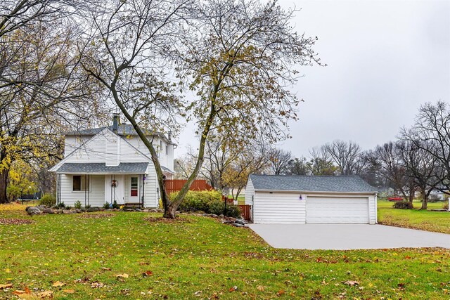 view of front of house featuring an outbuilding, a front yard, and a garage