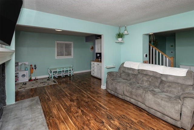 living room with dark hardwood / wood-style floors and a textured ceiling