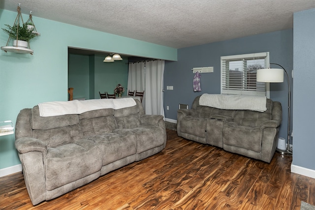 living room featuring dark hardwood / wood-style floors and a textured ceiling