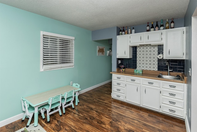 kitchen featuring white cabinetry, dark hardwood / wood-style floors, and sink