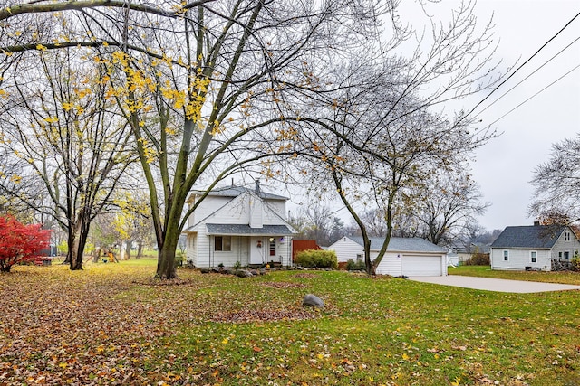 view of front of property featuring a garage, an outdoor structure, and a front lawn