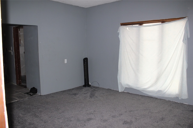 unfurnished room with dark colored carpet