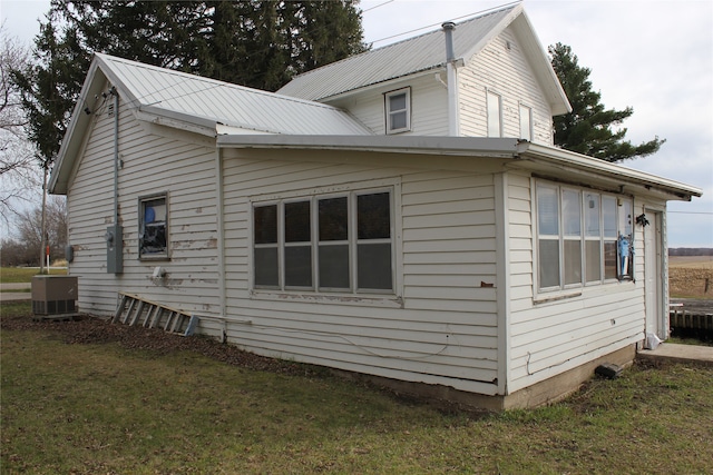 view of property exterior with central AC and a yard