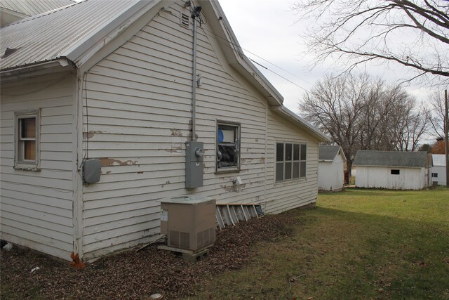 view of property exterior with a lawn, a shed, and central air condition unit