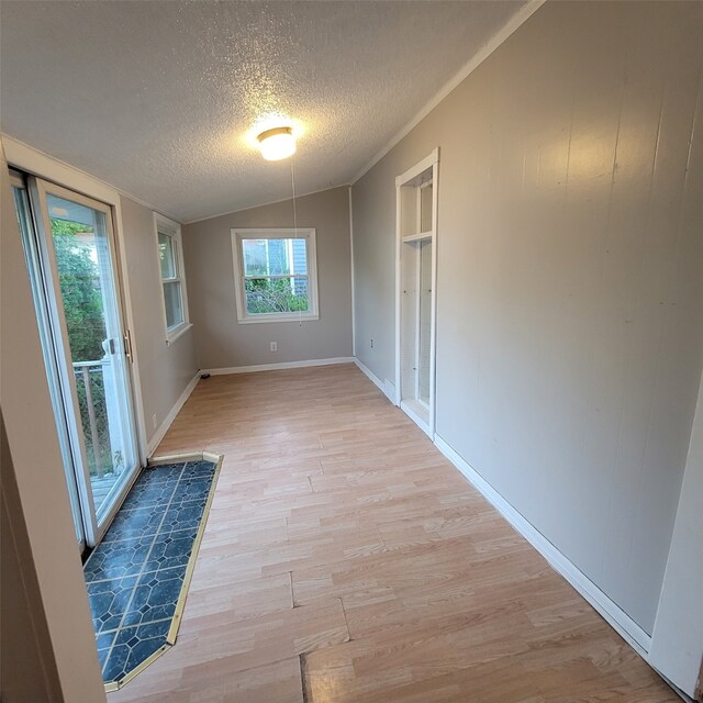 3829 1st St, Des Moines, IA 50313 - spare room featuring a textured ceiling, light wood-type flooring, lofted ceiling, and baseboards