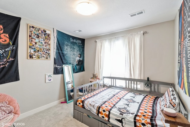 bedroom featuring light carpet and a textured ceiling