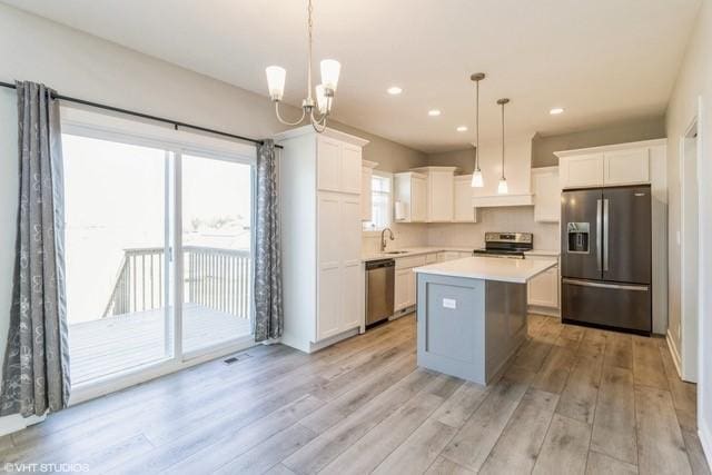 kitchen featuring plenty of natural light, white cabinets, appliances with stainless steel finishes, and light countertops
