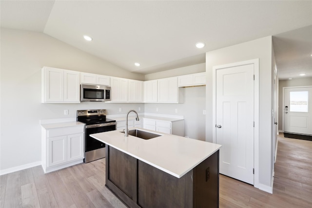 kitchen featuring sink, white cabinetry, a center island with sink, stainless steel appliances, and light hardwood / wood-style floors