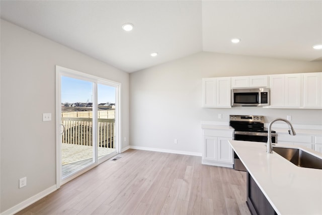 kitchen featuring white cabinetry, sink, vaulted ceiling, and appliances with stainless steel finishes