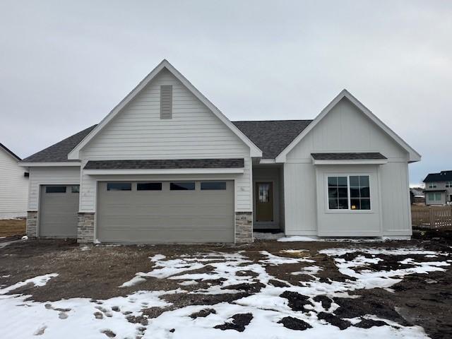 view of front of property with a garage, stone siding, and board and batten siding