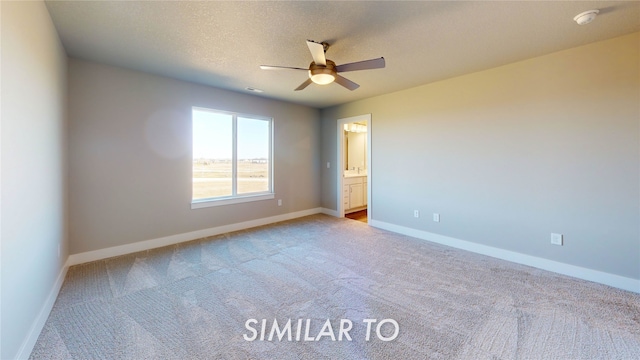 carpeted spare room with a textured ceiling and ceiling fan