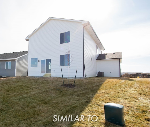 rear view of house featuring central AC and a lawn