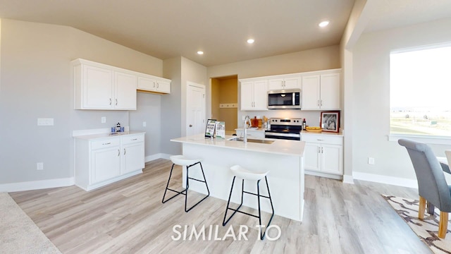 kitchen with white cabinetry, appliances with stainless steel finishes, a kitchen island with sink, and sink