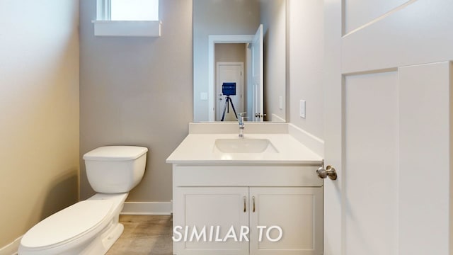 bathroom featuring vanity, hardwood / wood-style floors, and toilet