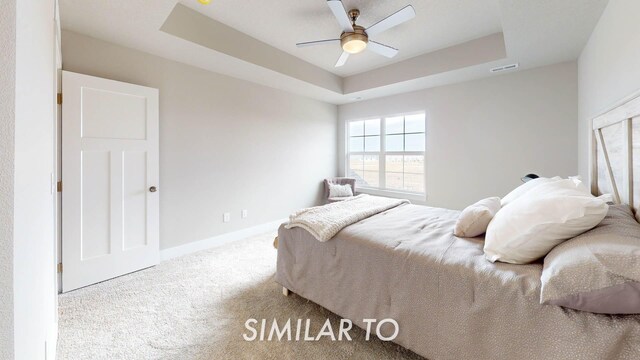 bedroom featuring carpet flooring, ceiling fan, and a tray ceiling